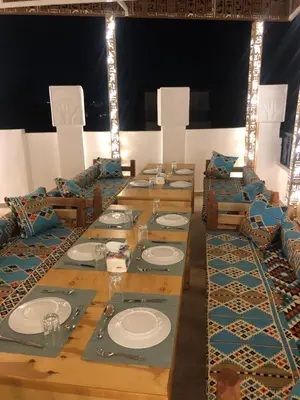 a long wooden table with plates on it at Amenti House - Private Villa & Retreat Center in Luxor