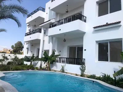 a villa with a swimming pool in front of a building at Amenti House - Private Villa & Retreat Center in Luxor