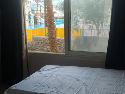 a bedroom with a window looking out at a pool at ميراج باي in Hurghada