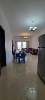 a dining room and living room with a table and chairs at Luxury Two Bedrom Apartment in Hurghada