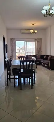 a dining room with a table and chairs and a couch at Luxury Two Bedrom Apartment in Hurghada