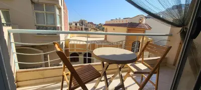 a balcony with two chairs and a table on a balcony at Luxury Two Bedrom Apartment in Hurghada