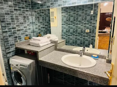 a bathroom with a sink and a washing machine at Sheraton St in Hurghada