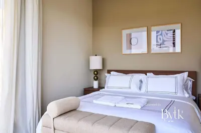 a bedroom with a large white bed and a chair at BYTK - Villa La Calma in Hurghada