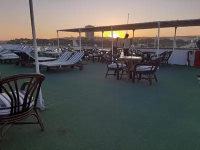 a person standing on the deck of a boat at Five Stars Nile Cruise from Luxor to Aswan 4 nights in Aswan