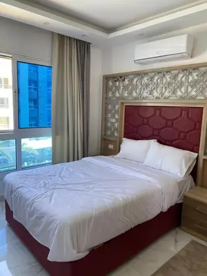a bedroom with a large bed with a red headboard at Fanader bay sea view apartment in Hurghada