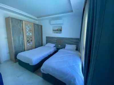 two beds in a small room with blue lights at Fanader bay sea view apartment in Hurghada