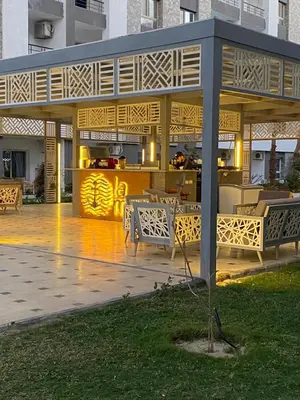 a pavilion with tables and chairs in a park at Fanader bay sea view apartment in Hurghada