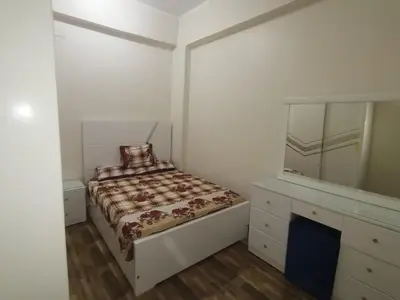 a bedroom with a bed and a dresser and a mirror at Hmmam in Quseir