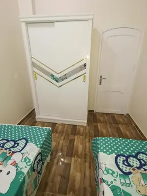 a room with a garage with a door and two beds at Hmmam in Quseir