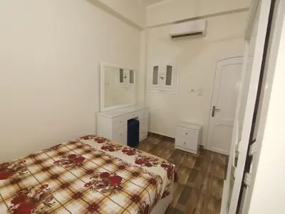 a small bedroom with a bed and a dresser at Hmmam in Quseir