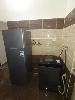 a refrigerator in a room with a trash can at Hmmam in Quseir