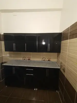 a kitchen with black cabinets and a granite counter top at Hmmam in Quseir