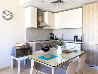 a kitchen with a table and chairs and a clock at El Gouna at Birdnest in Hurghada