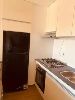 a kitchen with a black refrigerator and a sink at Luxury Chalet in Alsaraya, Overlooking All of Sahl Hasheesh with Stunning Pool & Red Sea Views in Hurghada