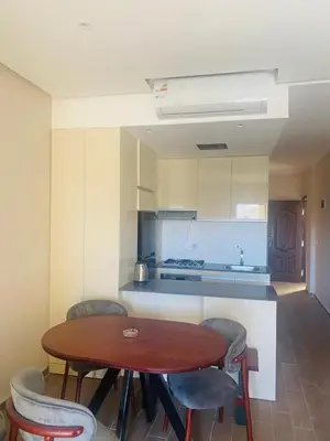 a kitchen with a wooden table and chairs in a room at Luxury Chalet in Alsaraya, Overlooking All of Sahl Hasheesh with Stunning Pool & Red Sea Views in Hurghada