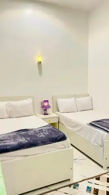 two beds in a room with white walls at Star - private apartments in Luxor