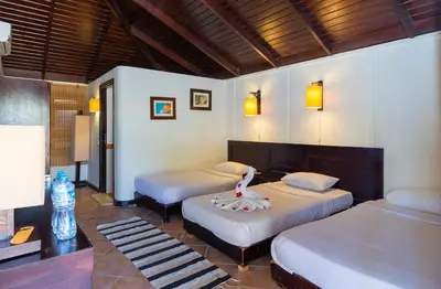 a bedroom with two beds and a table with a doll on it at Abu Dabbab Lodge in Abu Dabab
