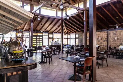 a restaurant with tables and chairs in a building at Abu Dabbab Lodge in Abu Dabab