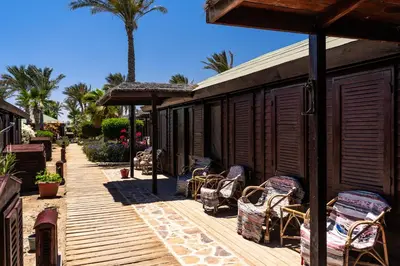 a group of chairs sitting on a wooden deck at Abu Dabbab Lodge in Abu Dabab
