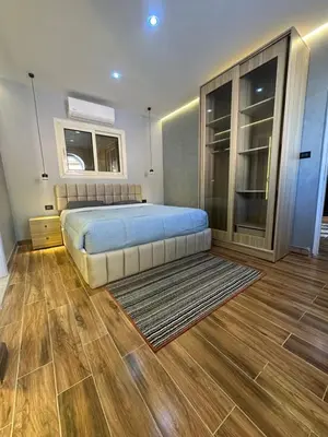 a bedroom with a large bed and a wooden floor at Mashrabiya one bed room apartment in Hurghada