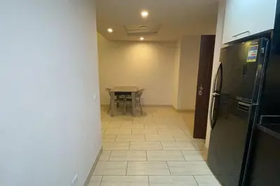 a kitchen with a table and a black refrigerator at Family apartment Aldau Heights in Hurghada
