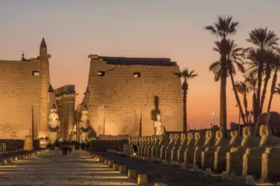 a building with palm trees in front of it at Nile Cruise 3 nights From Aswan to Luxor in Aswan