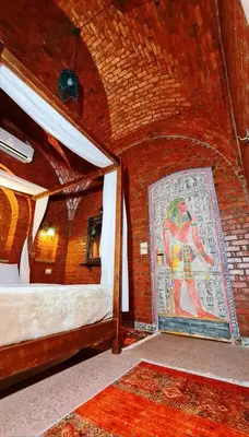 a room with two beds and a painting of a man at Luxor Tower in Luxor