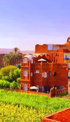 a red brick building in the middle of a field at Luxor Tower in Luxor