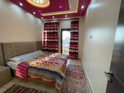 a bedroom with a bed and a window with curtains at Galaxy Aldau heights 2 bedrooms in Hurghada