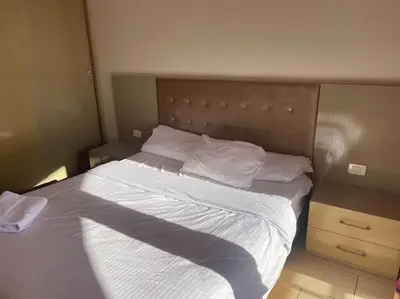 a bed with white sheets and pillows in a bedroom at Galaxy Aldau heights 2 bedrooms in Hurghada