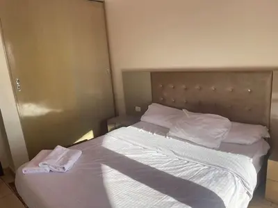 a large bed with white sheets and pillows on it at Galaxy Aldau heights 2 bedrooms in Hurghada