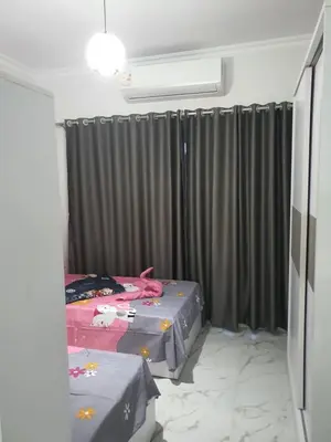 a bedroom with two twin beds and curtains at Juliana Beach Resort AG01 in Hurghada
