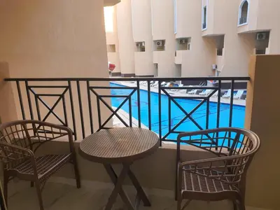 a balcony with two chairs and a swimming pool at Juliana Beach Resort AG01 in Hurghada