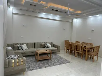 a living room with a couch and a table and chairs at فيلا ايلا ترافيل in Luxor
