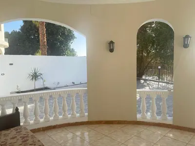 a room with two arched windows and a balcony at villa on Nile in Luxor