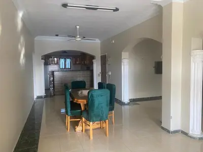a dining room with a table and green chairs at villa on Nile in Luxor