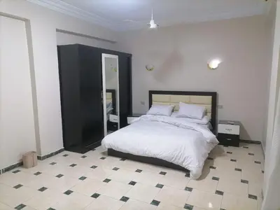 a bedroom with a large bed and a tiled floor at villa on Nile in Luxor
