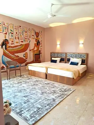 a bedroom with two beds and a rug at MAGIC GUEST HOUSE - Δ Relax Pur Δ 15 MiN TO ASWAN in Aswan