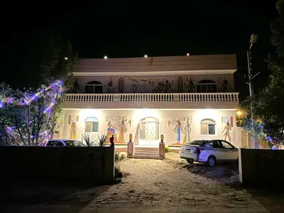 a house with cars parked in front of it at night at MAGIC GUEST HOUSE - Δ Relax Pur Δ 15 MiN TO ASWAN in Aswan