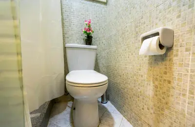 a bathroom with a toilet with a flower on the wall at Lazur Pool Apartment's - El Kawsar, Hurghada - Egypt in Hurghada