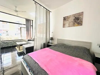 a bedroom with a pink bed and a couch at Falcon Loft Studio Sheraton Road in Hurghada