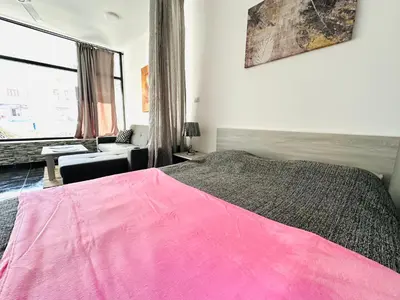 a bedroom with a pink bed and a living room at Falcon Loft Studio Sheraton Road in Hurghada