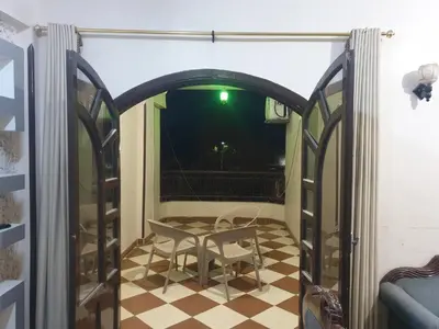 a room with a table and a checkerboard floor at El Quarn Apartment in ‘Ezbet Abu Ḥabashi