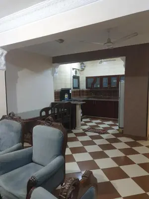 a living room with chairs and a checkered floor at El Quarn Apartment in ‘Ezbet Abu Ḥabashi