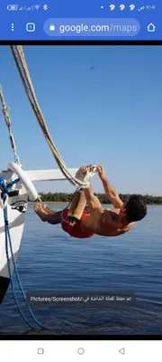two men are hanging from ropes on a boat at Nuba Tod Sailling boat in Aswan