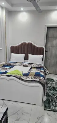 a bedroom with a large bed with a wooden headboard at King Mina Nubian House in Aswan