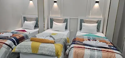 a room with two beds with colorful blankets and pillows at King Mina Nubian House in Aswan