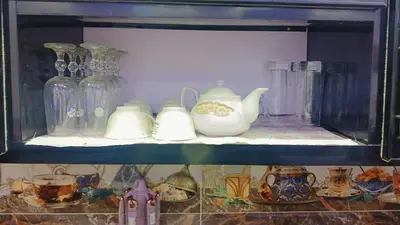 a shelf with glass vases and other items on it at اهلا بيكم في بيتنا in Jazīrat al ‘Awwāmīyah
