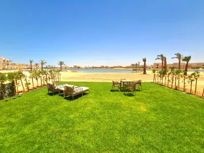 a lawn with tables and chairs on the beach at شيدوان الجونة in El Gouna